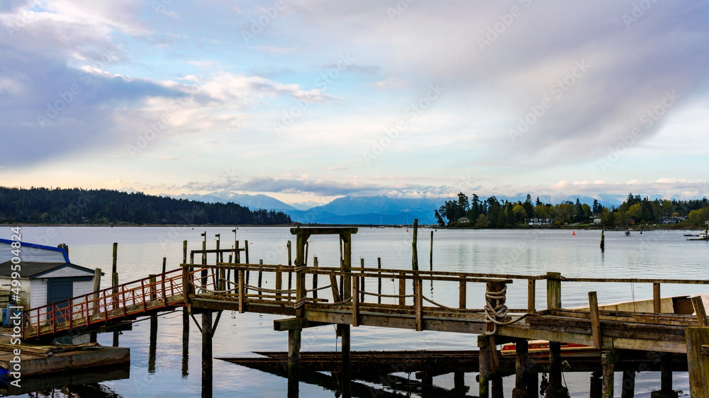 Marina at Sooke Harbor, BC, on a cloudy Spring morning with cloud-capped mountains on horizon. Marina at Sooke Harbor, BC, on a cloudy Spring morning with cloud-capped mountains on horizon.