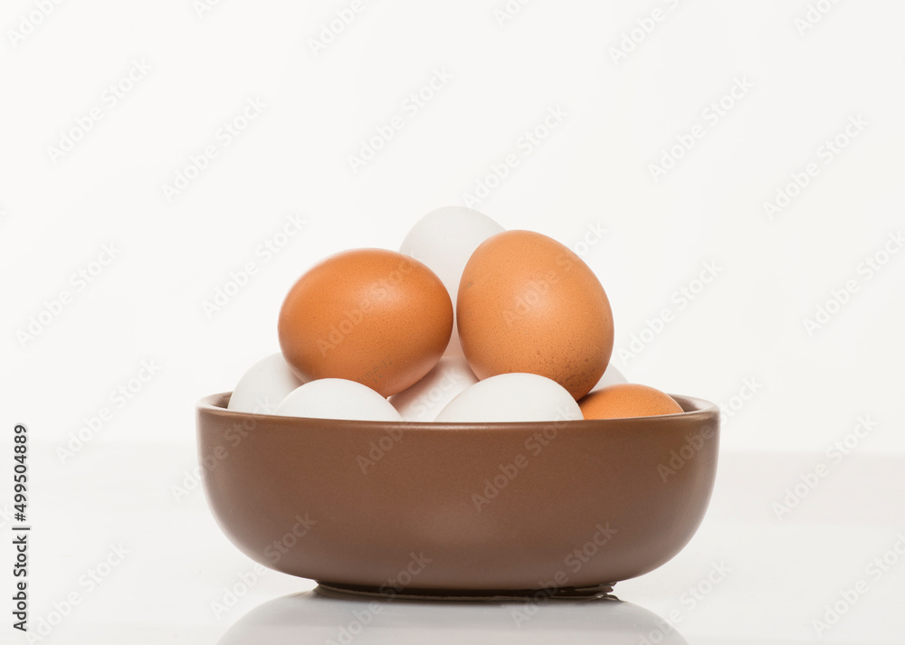 brown bowl with white and brown chicken eggs on white background brown bowl with white and brown chicken eggs on white background