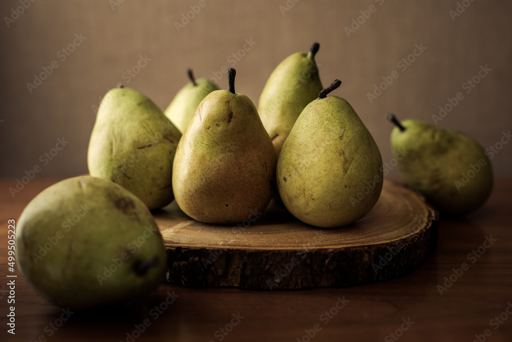 Rustic still life art of fresh ripe pears on wooden background.