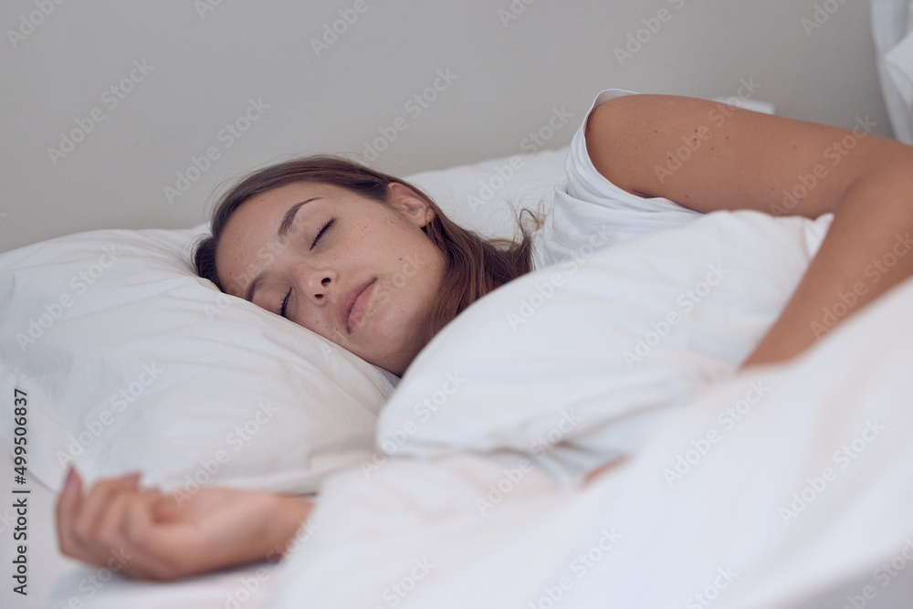 Sleep needs no explanation and is its own excuse. Shot of a young female sleeping in bed at home. Sleep needs no explanation and is its own excuse. Shot of a young female sleeping in bed at home.