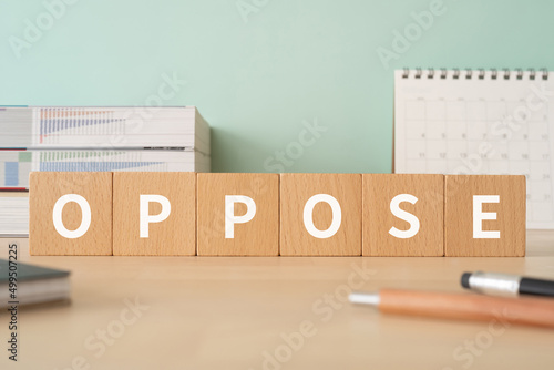 反対のイメージ｜「OPPOSE」と書かれた積み木が置かれたデスク
