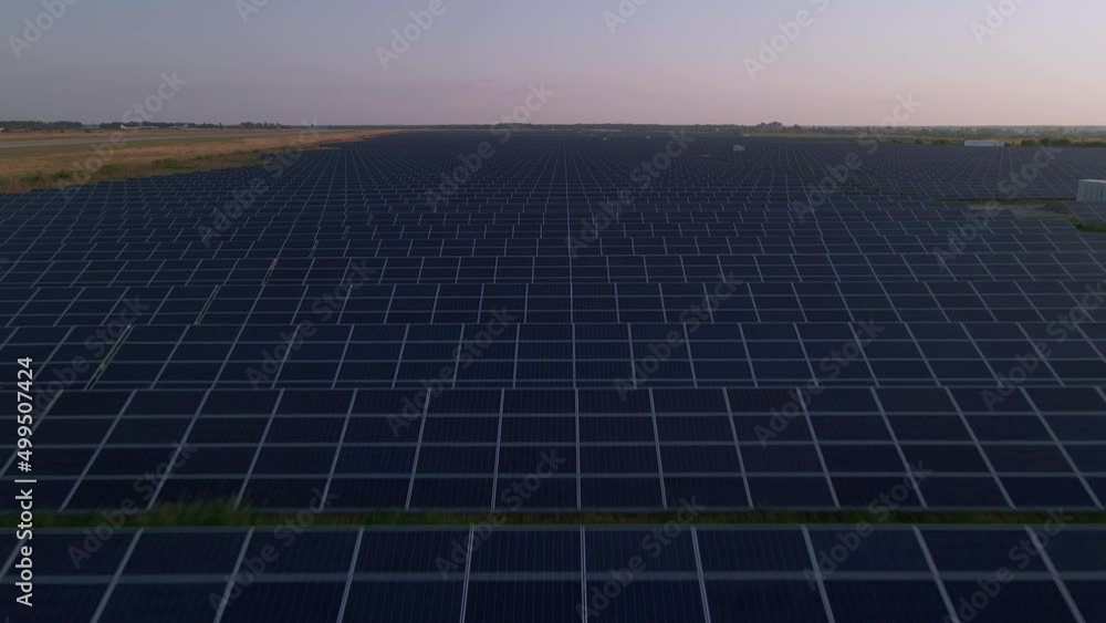 Aerial drone view of large solar panels at a solar farm at bright sunset in early winter. Solar cell power plants Aerial drone view of large solar panels at a solar farm at bright sunset in early winter. Solar cell power plants