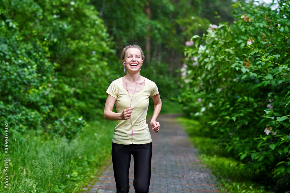 Running woman atletic spotsman trains in the summer park. Outdoor fitness portrait after rain Running woman atletic spotsman trains in the summer park. Outdoor fitness portrait after rain