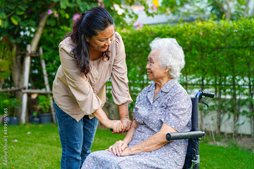 Caregiver help Asian elderly woman disability patient sitting on wheelchair in park, medical concept. Caregiver help Asian elderly woman disability patient sitting on wheelchair in park, medical concept.