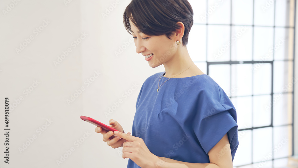 スマホを見ながら室内を歩く女性