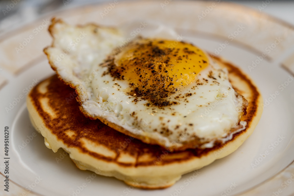 American breakfast. Fried egg over a pancake. American breakfast. Fried egg over a pancake.
