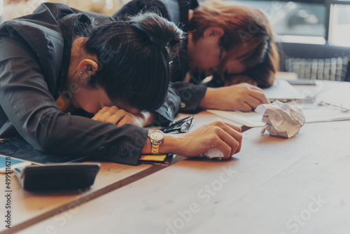 Top view two Asian businesswoman overworked at office desk feel stressful anxiety with serious problems. Two Woman exhaustion depress, mental burnout feeling tired frustrate at company office concept