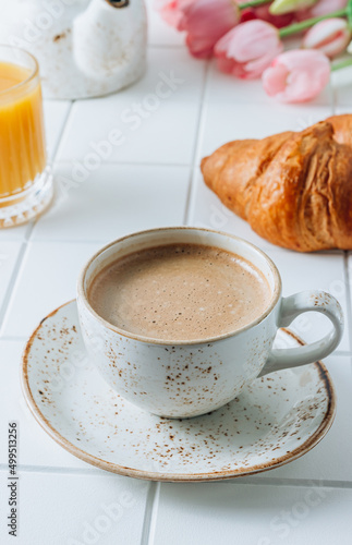 Fototapeta Naklejka Na Ścianę i Meble -  French Breakfast with Croissants, Orange Juice and Coffee with pink tulips