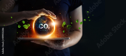 Man hold earth energy at night on tablet depicting the issue and reduce CO2 emissions carbon. Global warming and climate change. Energy saving, Sustainable development. Earth day. photo