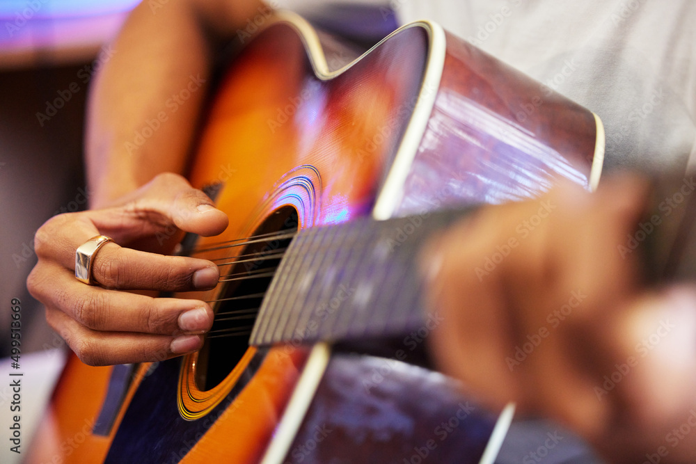 Fototapeta premium Hes hitting all the right notes. Cropped shot of an unrecognizable male musician playing his guitar at home.