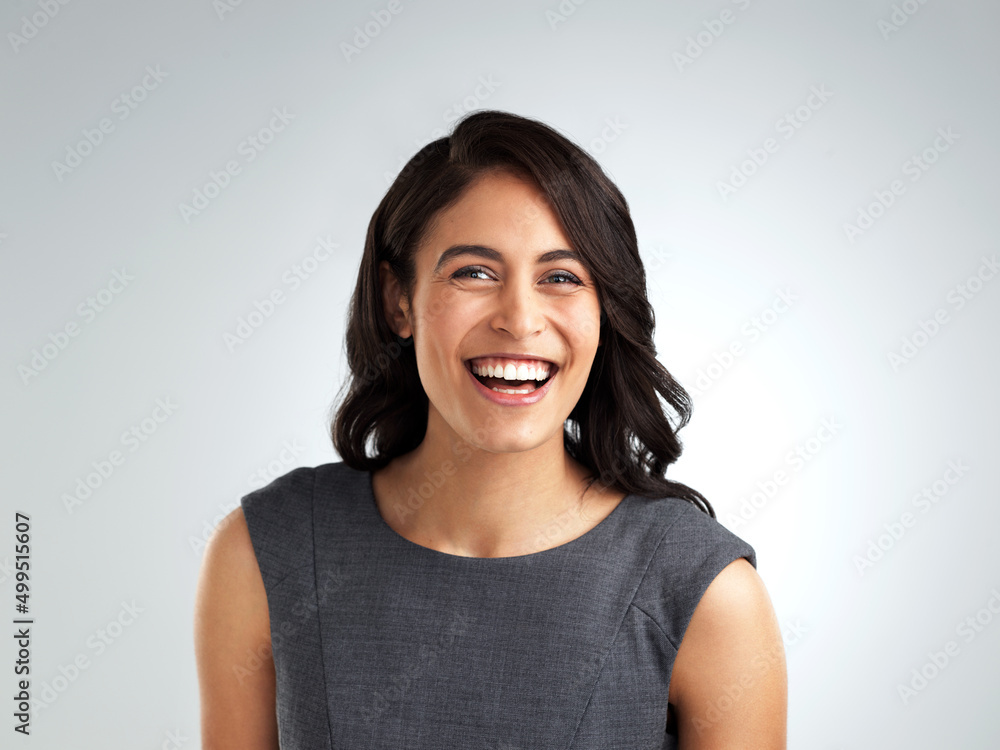 Your happiness is all that matters. Shot of a beautiful young woman laughing while standing against a white background. Your happiness is all that matters. Shot of a beautiful young woman laughing while standing against a white background.