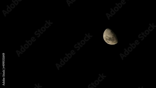 Rising moon with sunlight reflected in a black night sky over de right up frame side