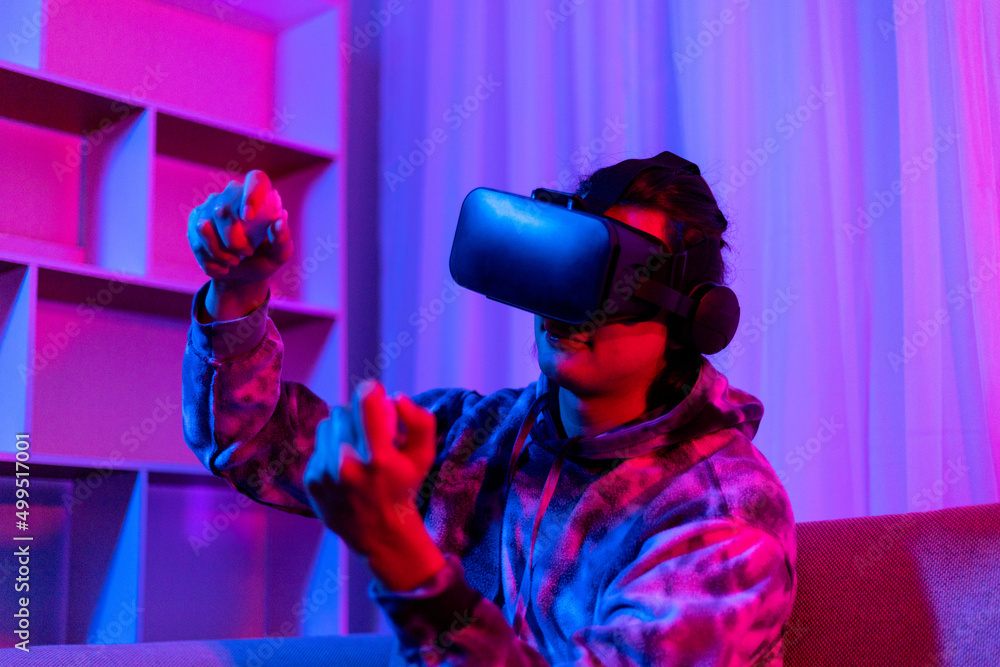 Man wears virtual reality glasses and uses joystick to play games with fun, VR, Future games, Technology, Red and blue background, Touch Controller, Bluetooth Remote Controller, VR game concept.