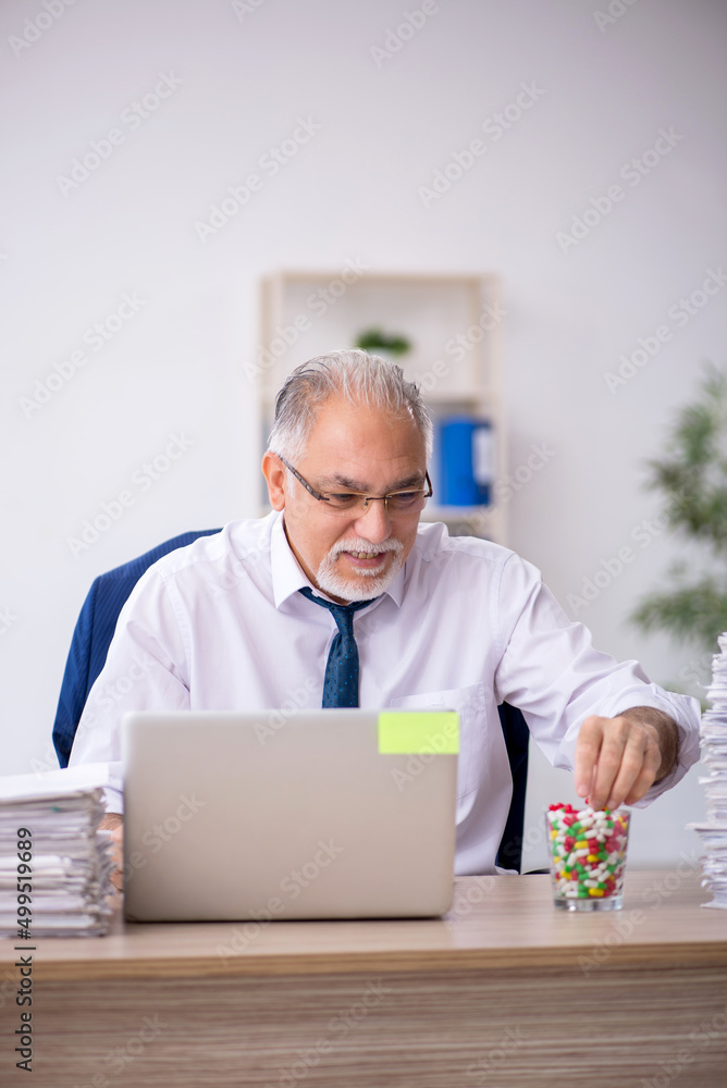 Old male employee feeling bad in the office Old male employee feeling bad in the office