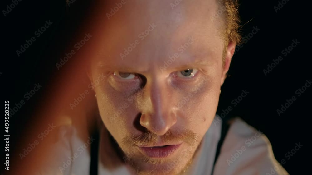 Portrait of Handsome Man Artist in theatre or a musician emotionally shows a performance looking at camera gesturing with his hands, sing and dancing in the dark room isolated on black. Portrait of Handsome Man Artist in theatre or a musician emotionally shows a performance looking at camera gesturing with his hands, sing and dancing in the dark room isolated on black.