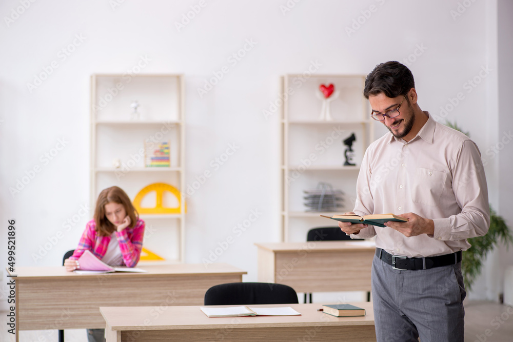 Young male teacher and redhead girl in the classroom Young male teacher and redhead girl in the classroom