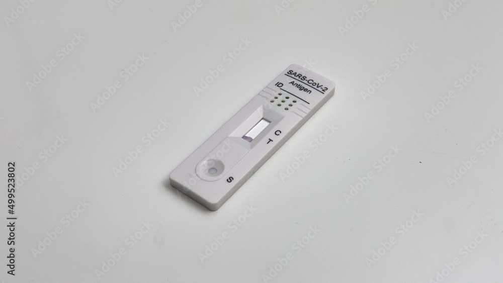 Performing COVID-19 antigen flow test. Flow to a positive result on the test pad. Wide framing. Performing COVID-19 antigen flow test. Flow to a positive result on the test pad. Wide framing.