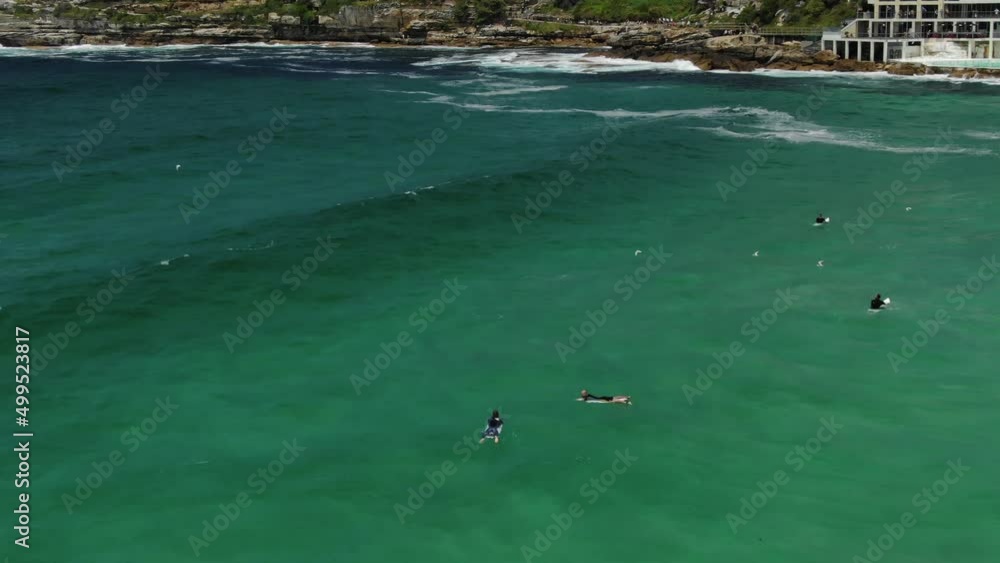 Surfers surfing in front of Bondi Icebergs Swimming Club, Australia. Aerial view Surfers surfing in front of Bondi Icebergs Swimming Club, Australia. Aerial view
