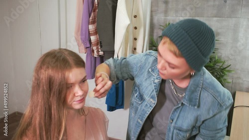 make-up artist applies foundation with sponge on model's face