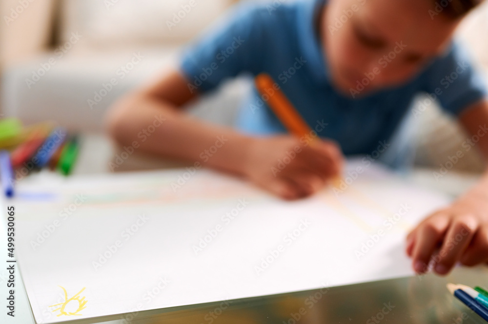 Selective focus. Little schoolboy drawing picture. Back to school. Home schooling and education at home Selective focus. Little schoolboy drawing picture. Back to school. Home schooling and education at home