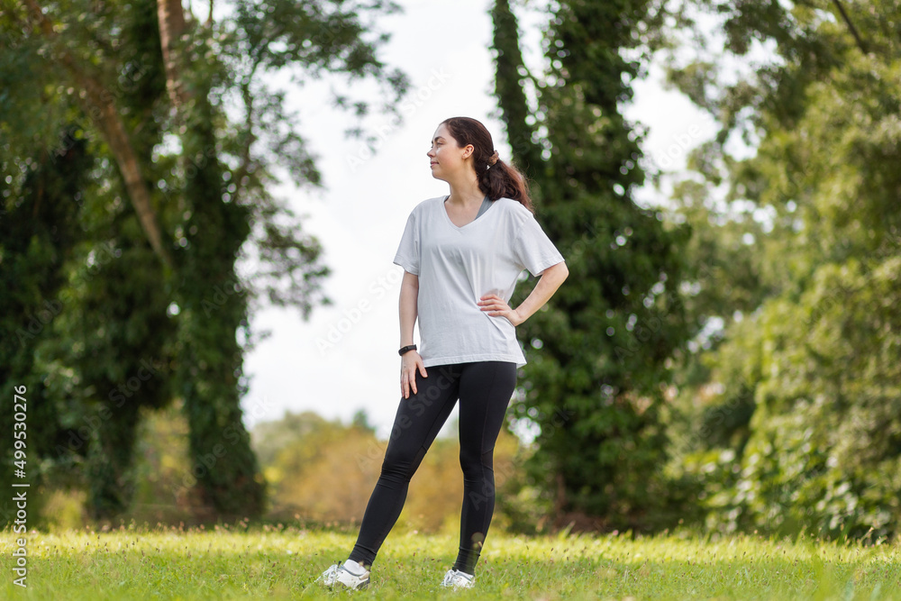 A young pretty woman in sports clothes relax at the summer park. Wellness and healthy lifestyle A young pretty woman in sports clothes relax at the summer park. Wellness and healthy lifestyle