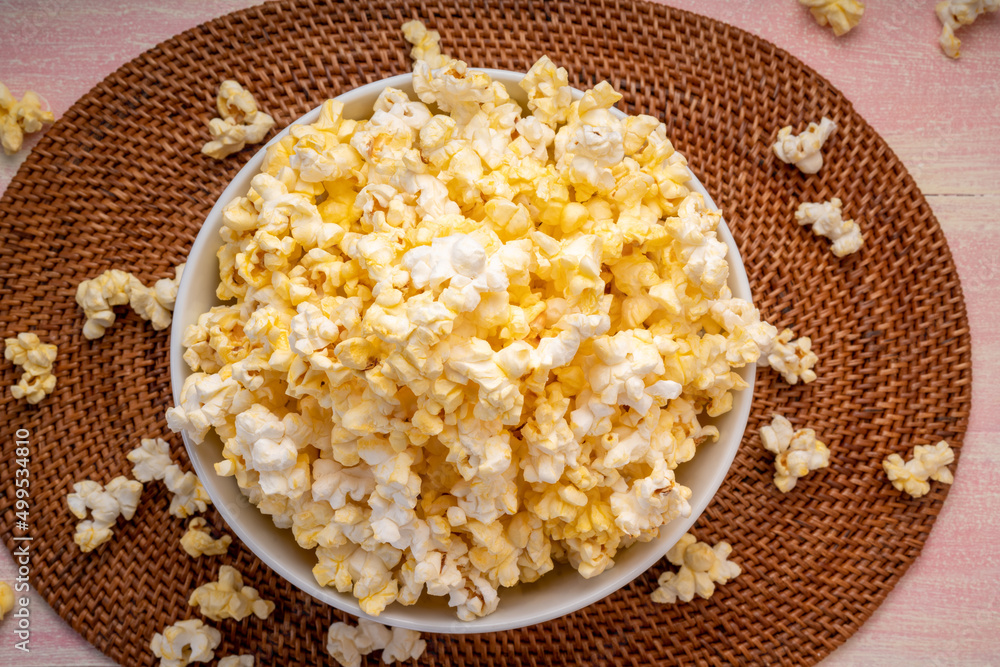 Popcorn in bown on wooden background. Popcorn in bowl on wooden table. Popcorn in bown on wooden background. Popcorn in bowl on wooden table.