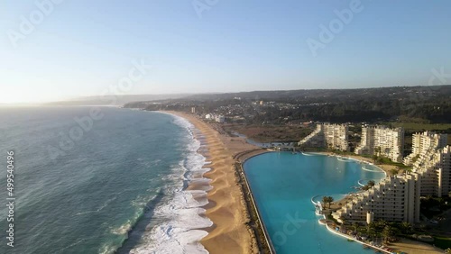 Flying over a huge swimming pool next to modern buildings at beach of Algarrobo, Chile photo