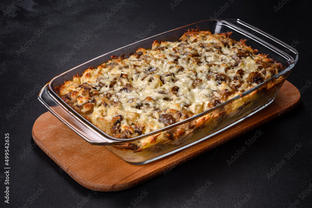A delicious nutritious dish with meat, mushrooms, vegetables and potatoes, baked in a creamy sauce in an oven A delicious nutritious dish with meat, mushrooms, vegetables and potatoes, baked in a creamy sauce in an oven