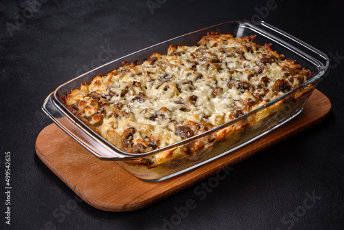 A delicious nutritious dish with meat, mushrooms, vegetables and potatoes, baked in a creamy sauce in an oven