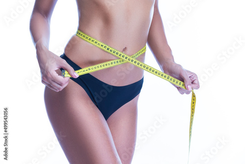 Good Fit Sexy Slim Caucasian Woman Body taking Measure Reading With Tape Measure in Hand In Front of Black Thong Isolated on White Background.