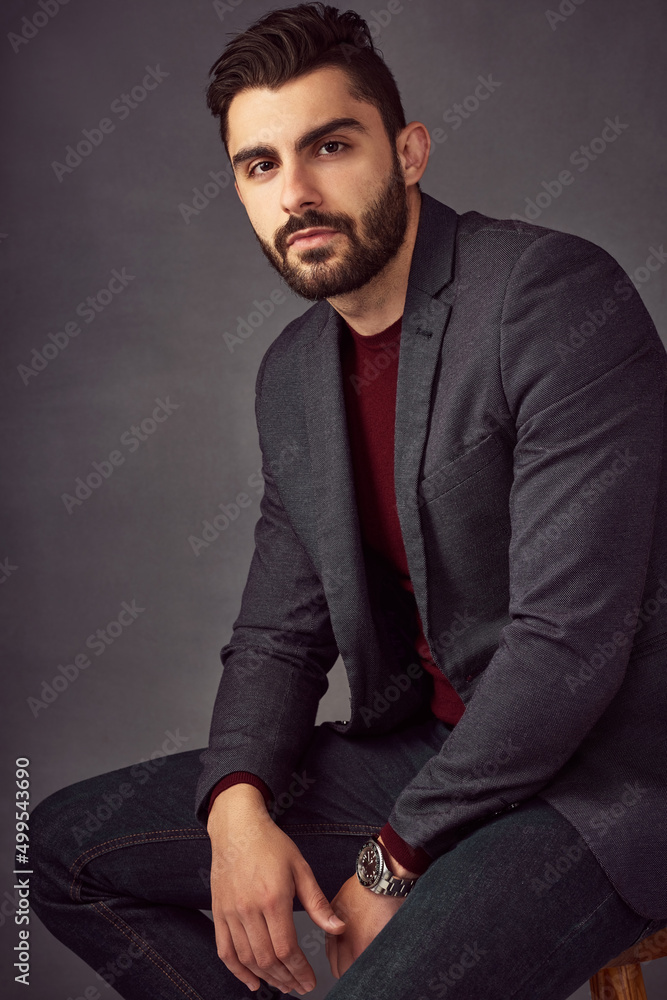 Hes got that captivating charm. Studio portrait of a handsome young man posing against a dark background. Hes got that captivating charm. Studio portrait of a handsome young man posing against a dark background.