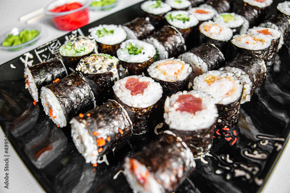 Sushi set close-up on black background. Traditional Japanese seafood. Delicious roll. Advert for food delivery service. Sushi set close-up on black background. Traditional Japanese seafood. Delicious roll. Advert for food delivery service.