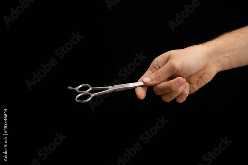 hand of a man handing and giving a scissors