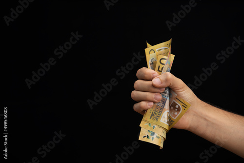 hand of a man squeezing australian dollars photo
