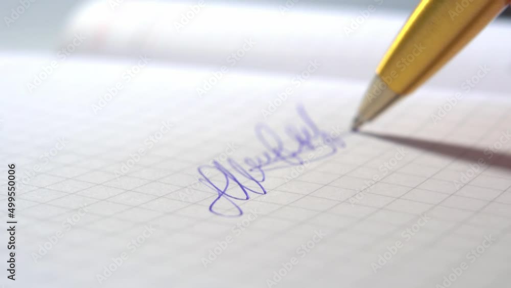 Teacher signing an exam with a pen in a student notebook. Macro. Signature close up Teacher signing an exam with a pen in a student notebook. Macro. Signature close up