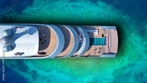 Aerial drone top down photo of luxury exotic yacht nose with wooden deck anchored in paradise turquoise bay © aerial-drone