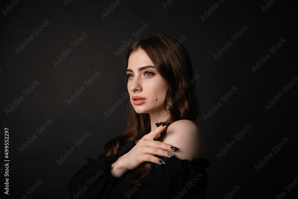 Portrait of a beautiful woman with long hair on a dark background.Girl with a charming smile. Portrait of a beautiful woman with long hair on a dark background.Girl with a charming smile.