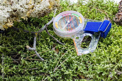 Compass for orienteering lies on the green grass