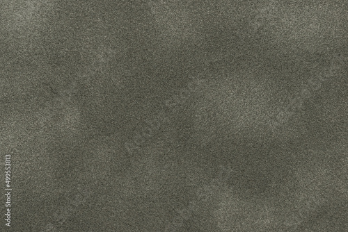Background of dark gray suede matte fabric closeup. Velvet matt texture of black nubuck textile. Velveteen pattern