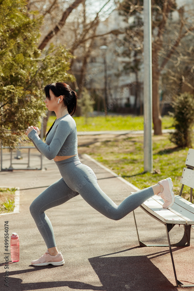 Fototapeta premium Young beautiful brunette woman doing sports on the street