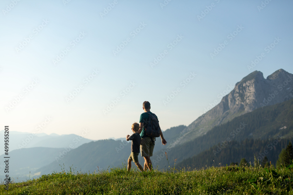 Father and son hiking with a  view in the Austrian Alps. Active family vacation concept
