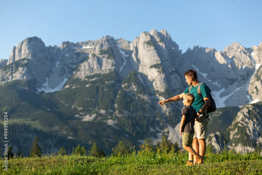 Family time in mountains. Father and son exploring  the Austrian Alps