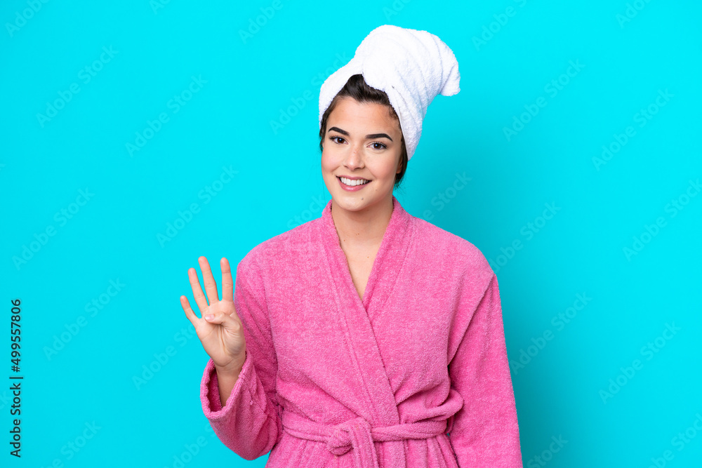 Young Brazilian woman with a bathrobe isolated on blue background happy and counting four with fingers Young Brazilian woman with a bathrobe isolated on blue background happy and counting four with fingers