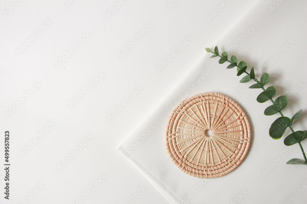 rattan coaster and white fabric background for cosmetic products. top view, copy space. rattan coaster and white fabric background for cosmetic products. top view, copy space.