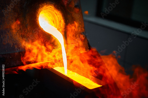 Obraz na plátne Pouring liquid gold into graphite casting form from furnace