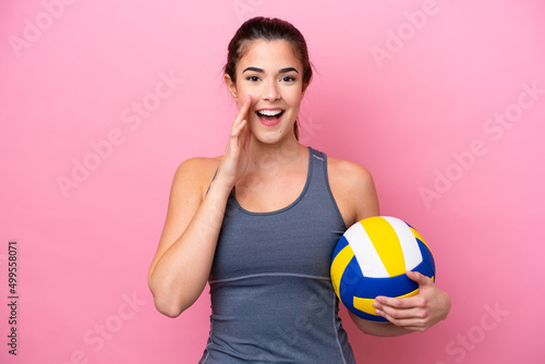 Young Brazilian woman playing volleyball isolated on pink background shouting with mouth wide open