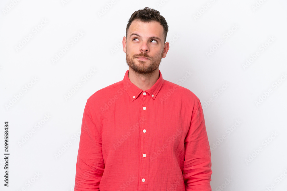 Young Brazilian man isolated on white background having doubts while looking up Young Brazilian man isolated on white background having doubts while looking up