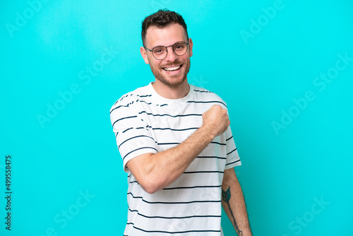 Young Brazilian man isolated on blue background celebrating a victory Fototapeta