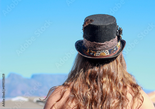 Lon-haired back view of young man with steampunk hippie hat photo