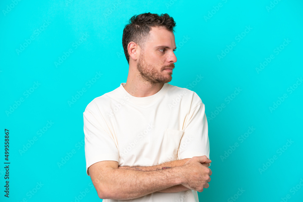 Young Brazilian man isolated on blue background keeping the arms crossed Young Brazilian man isolated on blue background keeping the arms crossed